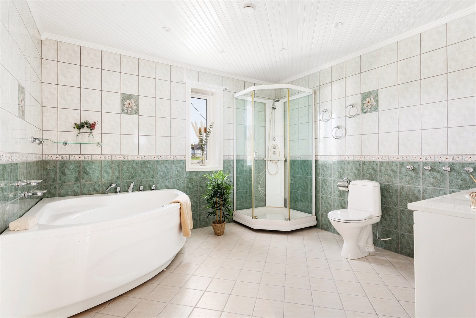 Badet er romslig med både badekar og dusj. Det er varmekabler i gulv. Innredningen er lys og meget innholdsrik med skap både under og over servanten i tillegg til et praktisk høyskap. Det er ekstra opplegg for vaskemaskin på badet. Galleribilde