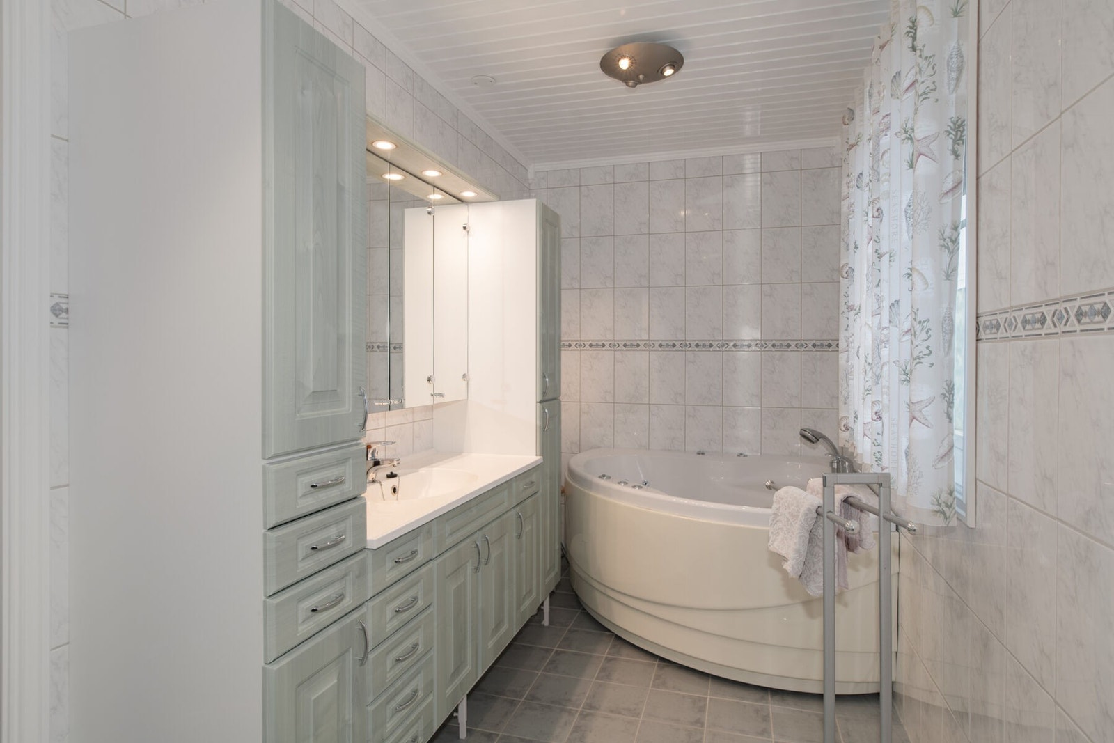 Stor baderomsinnredning og hjørneboblekar på hovedbadet Galleribilde