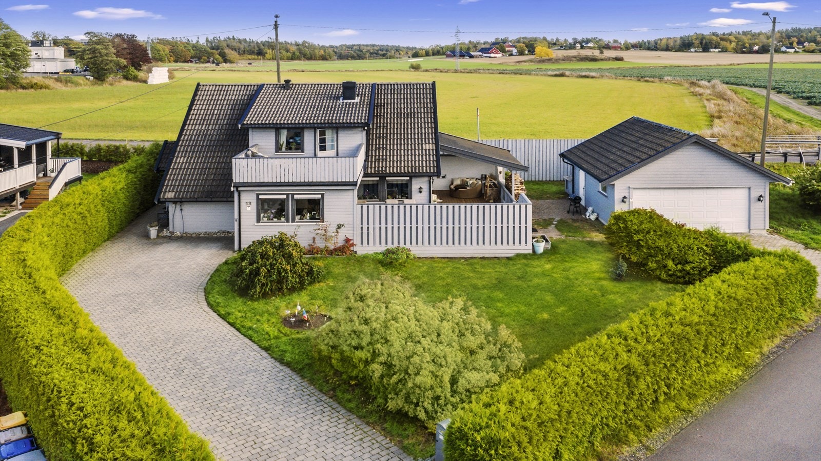 Tomten er fint opparbeidet med plen og beplantning, samt omkranset av hekk og gjerde. Galleribilde