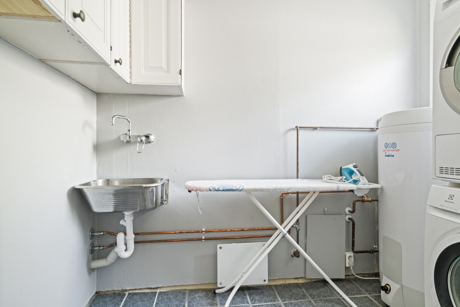 I denne etasjen finner du i tillegg vaskerom med flislagt gulv og tapet på vegger. Rommet er innredet med utslagsvask og opplegg for vaskemaskin. Galleribilde