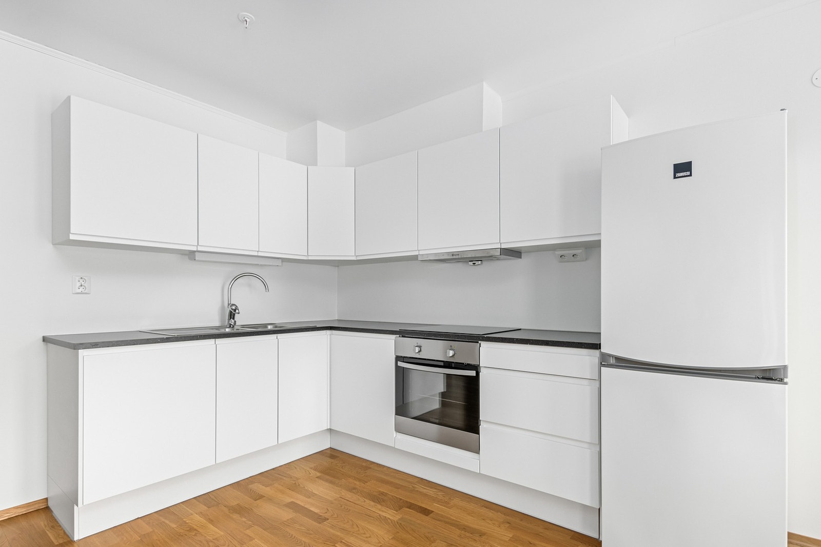 Kjøkken fra JKE med integrert komfyr, steketopp, vaskemaskin og frittstående kombiskap som følger med i handelen. Galleribilde