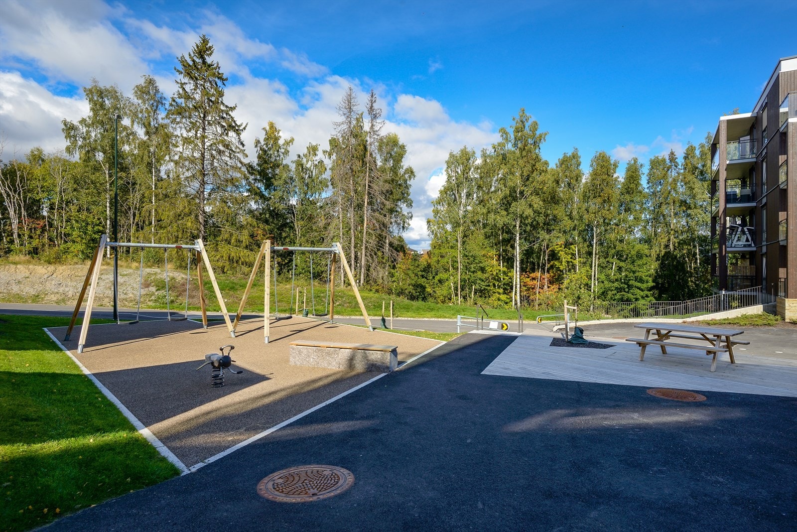 Her ligger boligene luftig og fritt, omgitt av grønn natur, og med umiddelbar nærhet til skoler, barnehager, idrettsanlegg, togstasjon, buddholdeplass, treningssenter, restauranter, caféer, matbutikker, shopping, helse og servicetilbud - ko Galleribilde