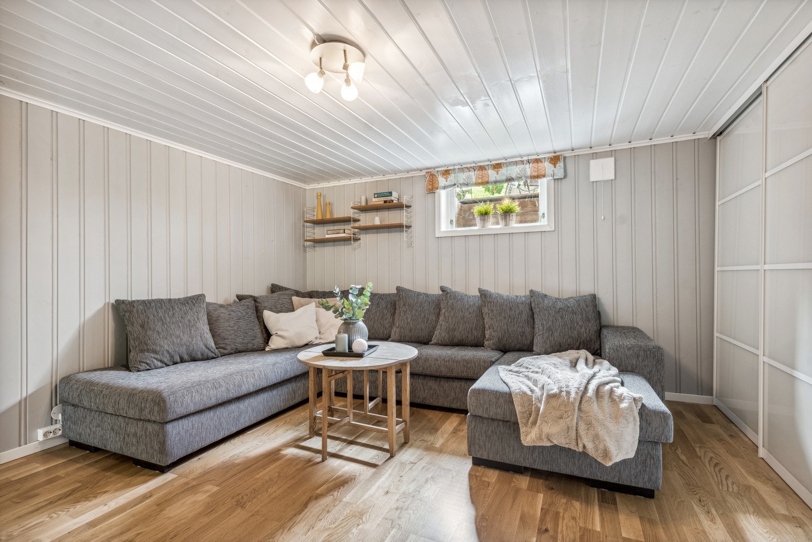 Nede i kjelleren ligger kjellerstuen. Her er det god plass til en romslig sofagruppe. Langs den ene veggen er det skyvedørsgarderobe for oppbevaring. Galleribilde