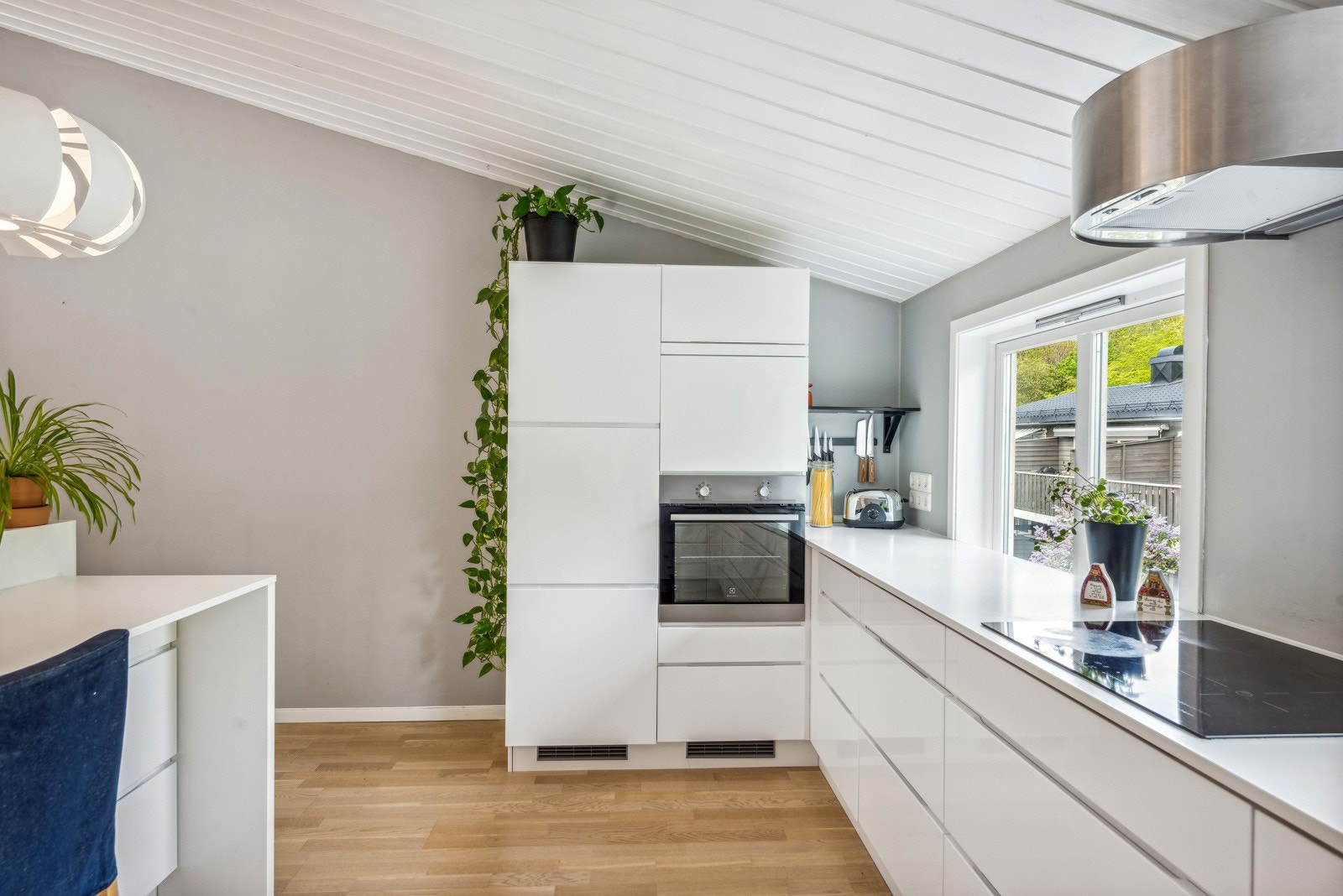 Hvit innredning og hvit benkeplate i gir et delikat uttrykk. I innredningen er det integrert platetopp, stekeovn, oppvaskmaskin og kjøleskap. Galleribilde