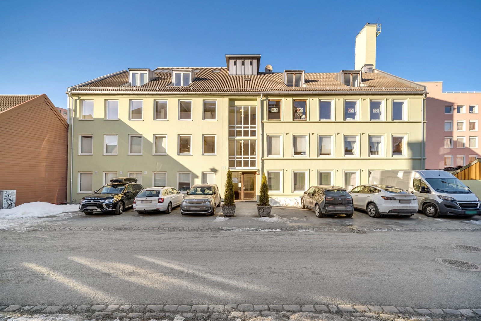 Fasade. Inngang til boligen. Parkeringsplasser utenfor som beboerne kan benytte seg (førstemann til mølla prinsippet) Galleribilde