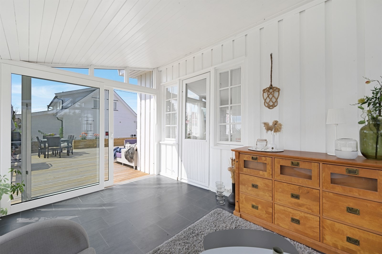 Vinterhage med stor glass skyvedør ut til veranda. Galleribilde