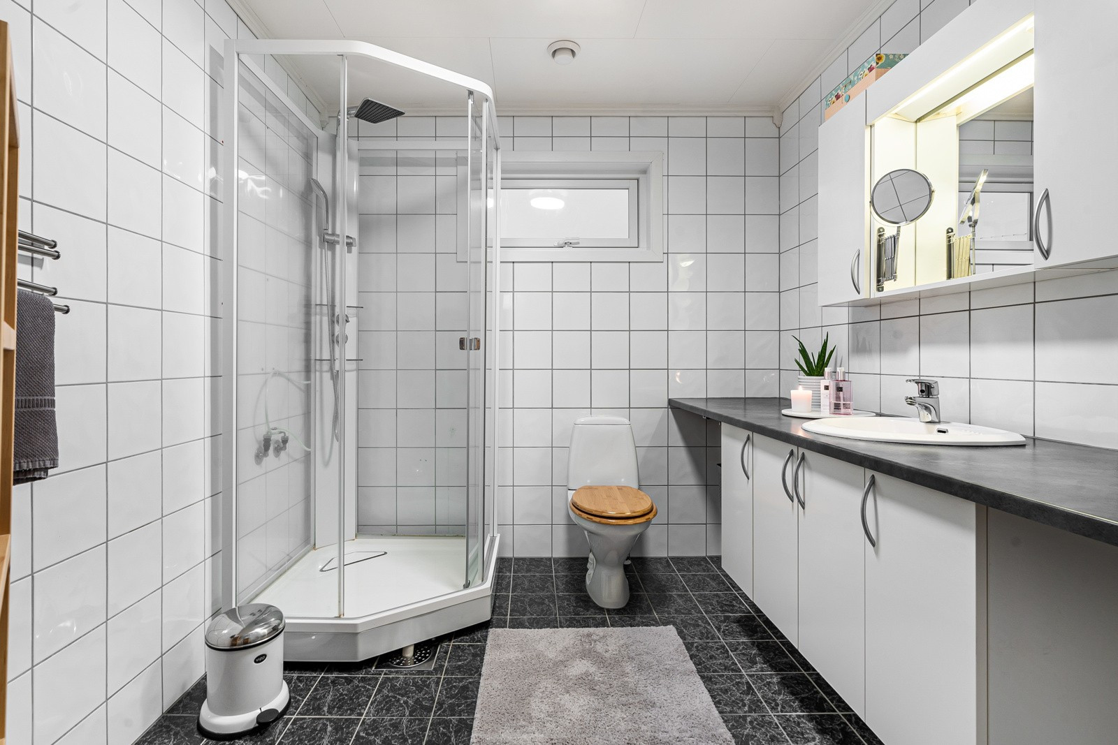 Badet i 2. etasje er innredet med dusjkabinett, toalett og servant med god oppbevaringsplass i skap under.