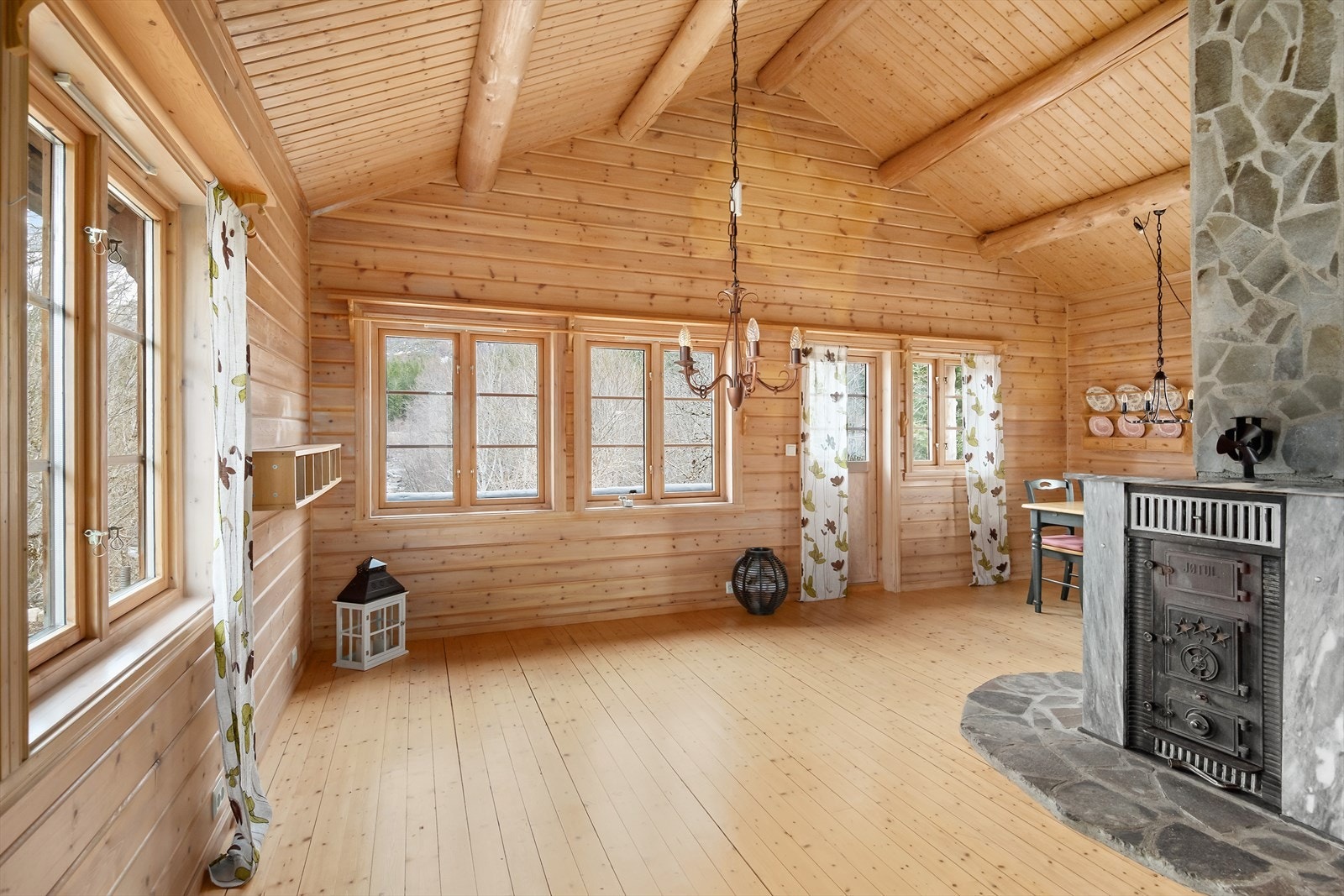 Det er flere vindusflater som slipper godt med lys inn i rommet, og vedovnen gir den gode lune hyttevarmen. Galleribilde