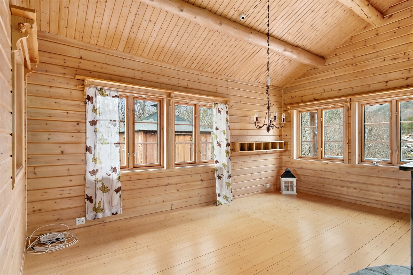 Tykke karakteristiske bjelker i taket gir hytta et pent preg, det er god takhøyde i rommet. Galleribilde