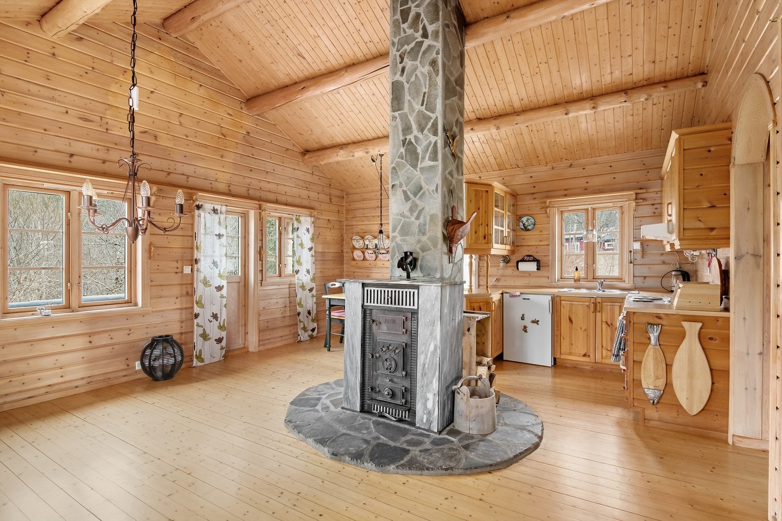Vedovnen på hytta er nydelig og er plassert midt i rommet slik at den kan sees fra hele stuerommet Galleribilde