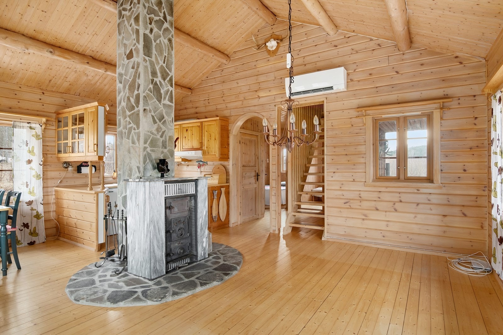 Utgang til gangen og de resterende rommene i hytta. På bildet kan man så vidt skimte trappen opp til hemsen fra gangen. Varmepumpe er også installert. Galleribilde