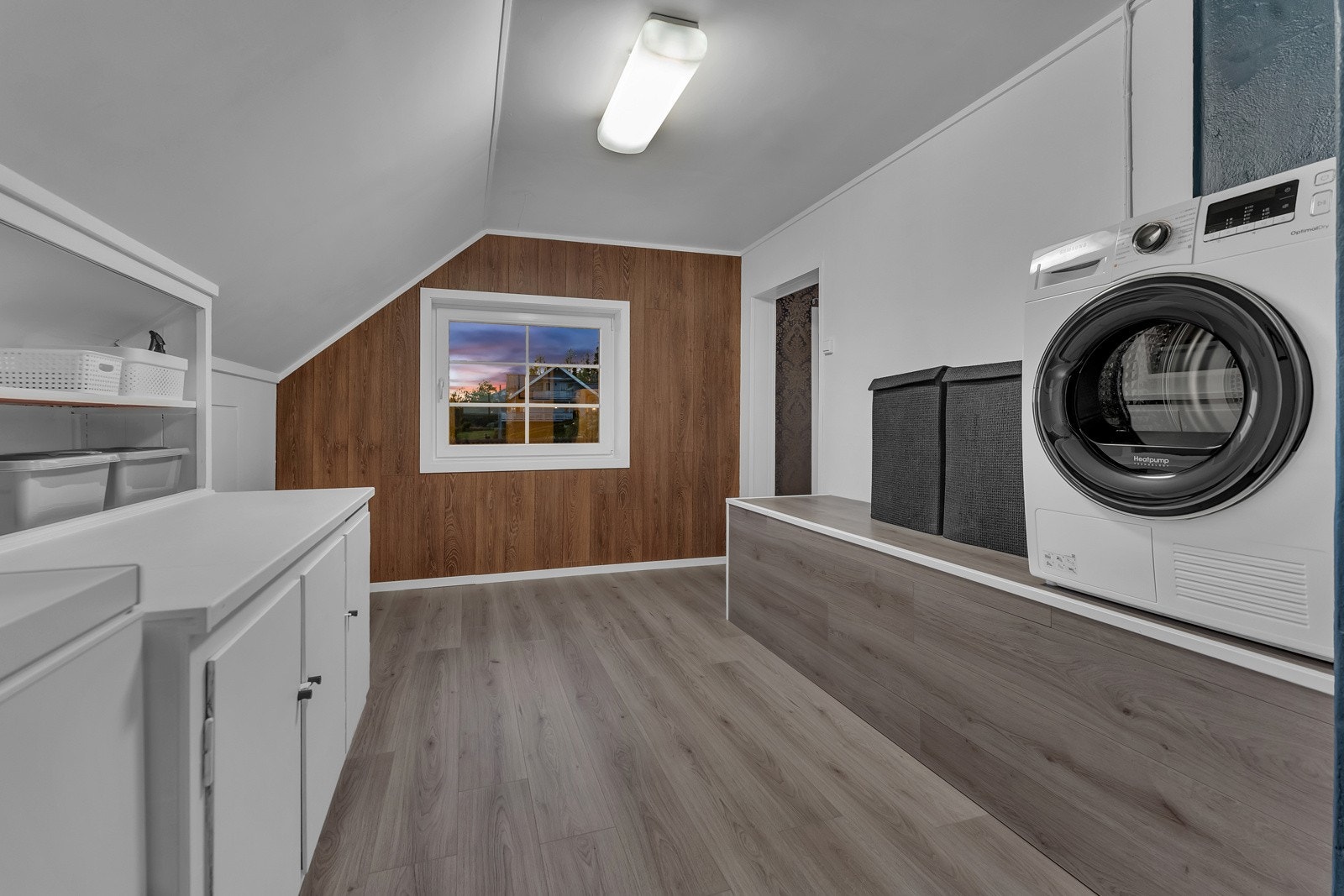 Vaskerom fra 70-tallet i kjelleretasje. Gulvflater av ubehandlet betong og malte overflater på vegger. Opplegg for vaskemaskin og dobbel stikkontakt på vegg. Galleribilde