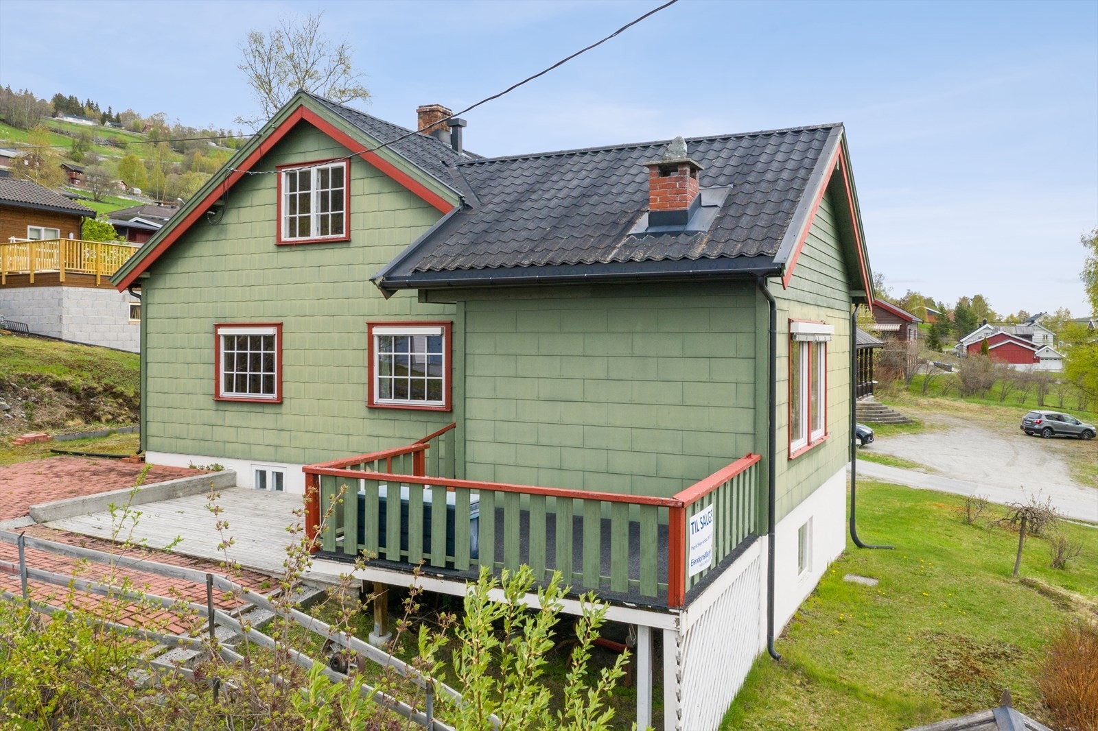 Utgang til terrasse fra stue med videre adkomst til teglsteinsbelagt platting og hagen Galleribilde