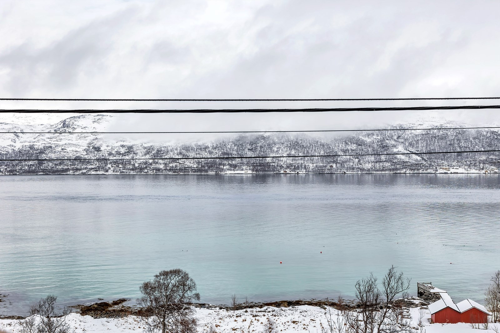 Utsikt mot Ringvassøya og ned til felles kai - båtplass og mulighet for å oppføre naust