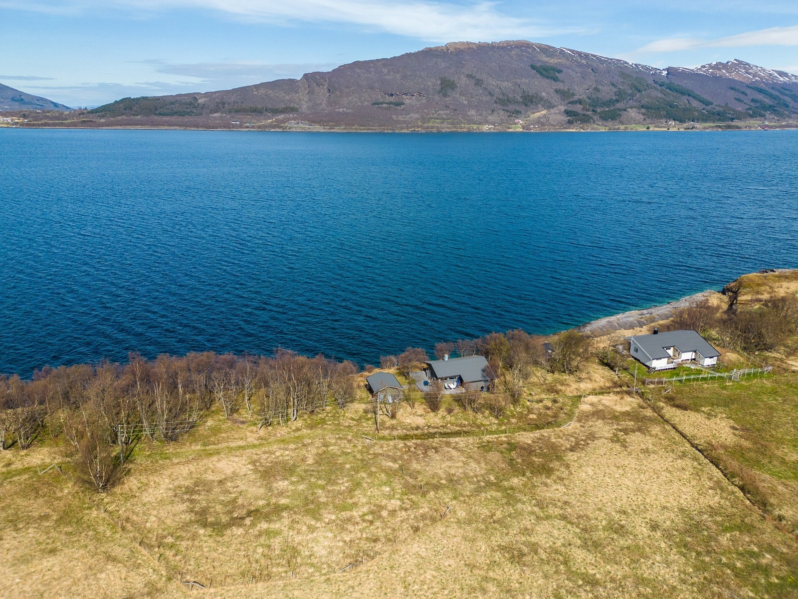 Dronebilde av hytta, annekset og nærområdet Galleribilde