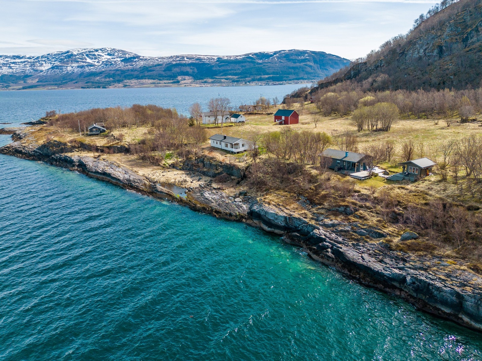Dronebilde av hytta, annekset og nærområdet Galleribilde