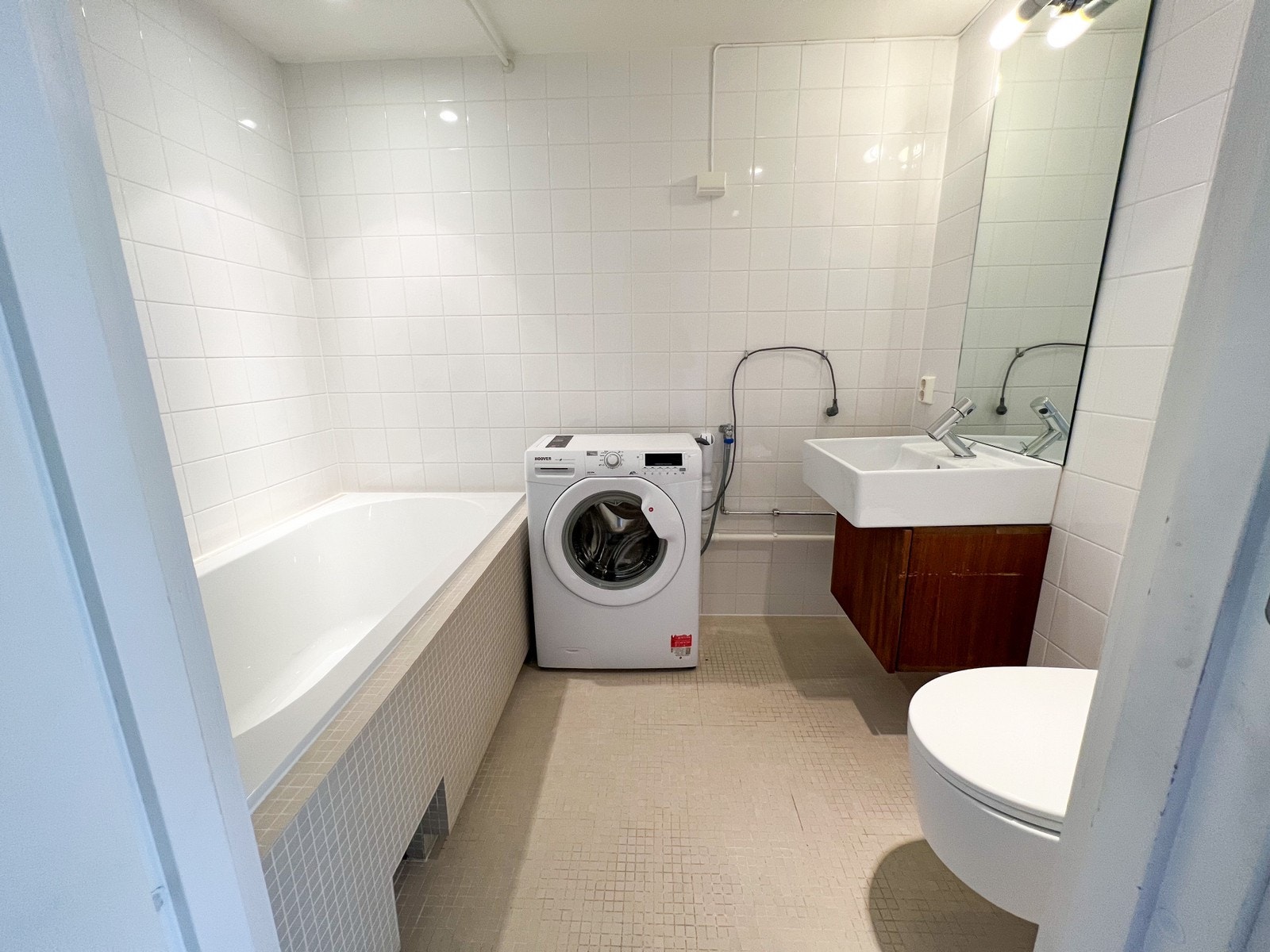 Romslig bad med vaskemaskin og badekar. Galleribilde