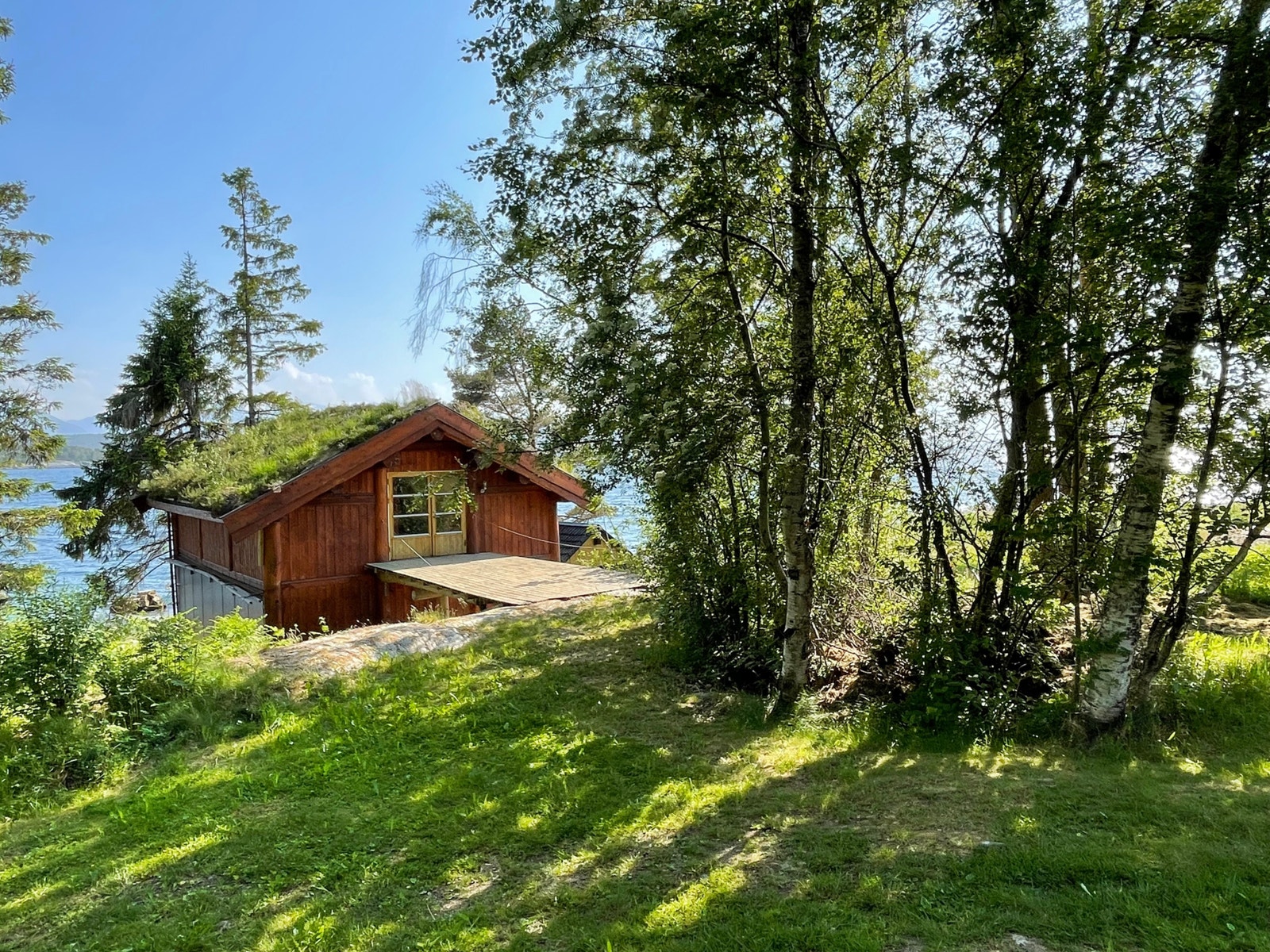sjøhus stikker opp nedenfor berget Galleribilde