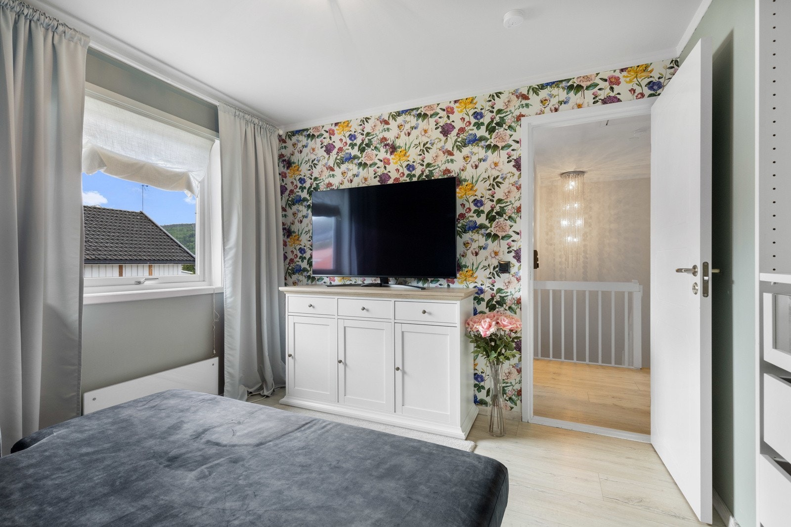 Rommene her holdt i behagelige farger, hvor ett har pen tapet med blomstermotiv på kontrastvegg. Galleribilde