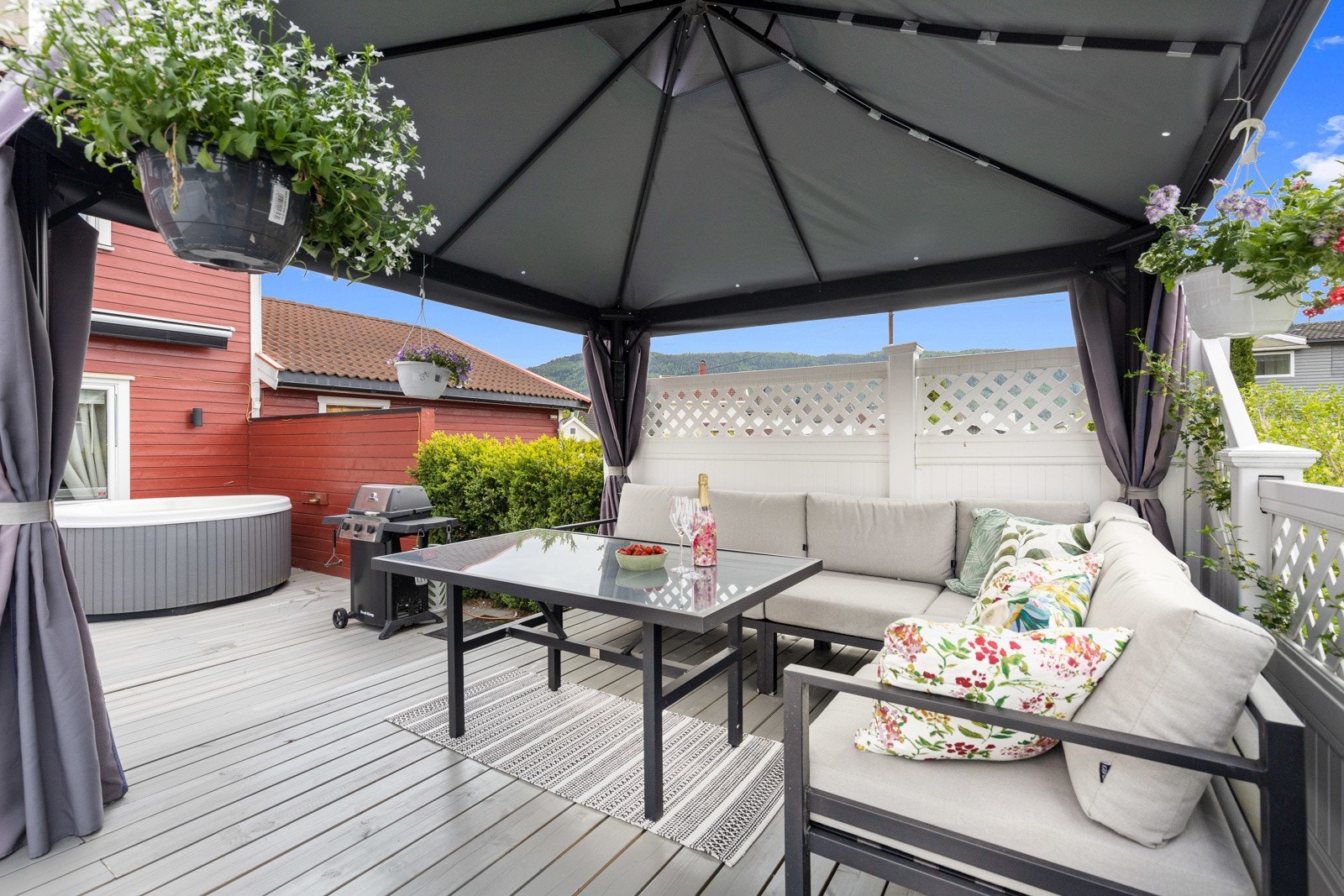 Uteplassen har terrassebord på dekke, bred markise og flere levegger. Galleribilde