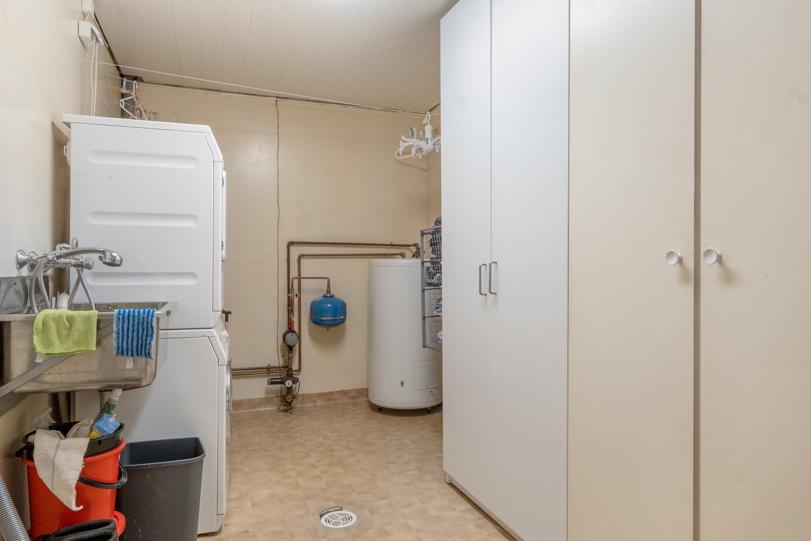 Eget vaskerom med opplegg for vaskemaskin/tørktrommel og skap for oppbevaring av vaskeartikler Galleribilde