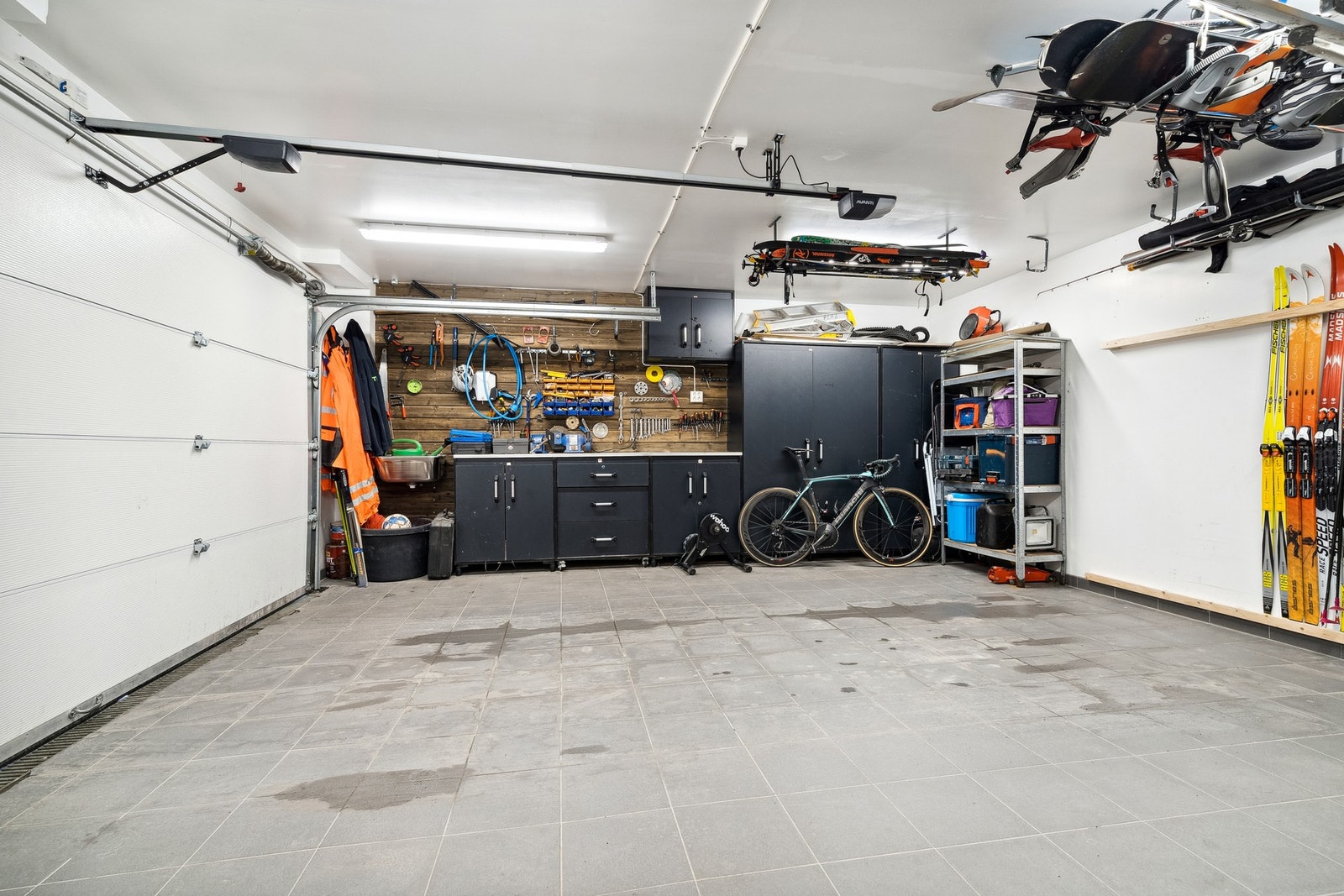 Stor garasje med flislagt gulv og arbeidsbenk Galleribilde