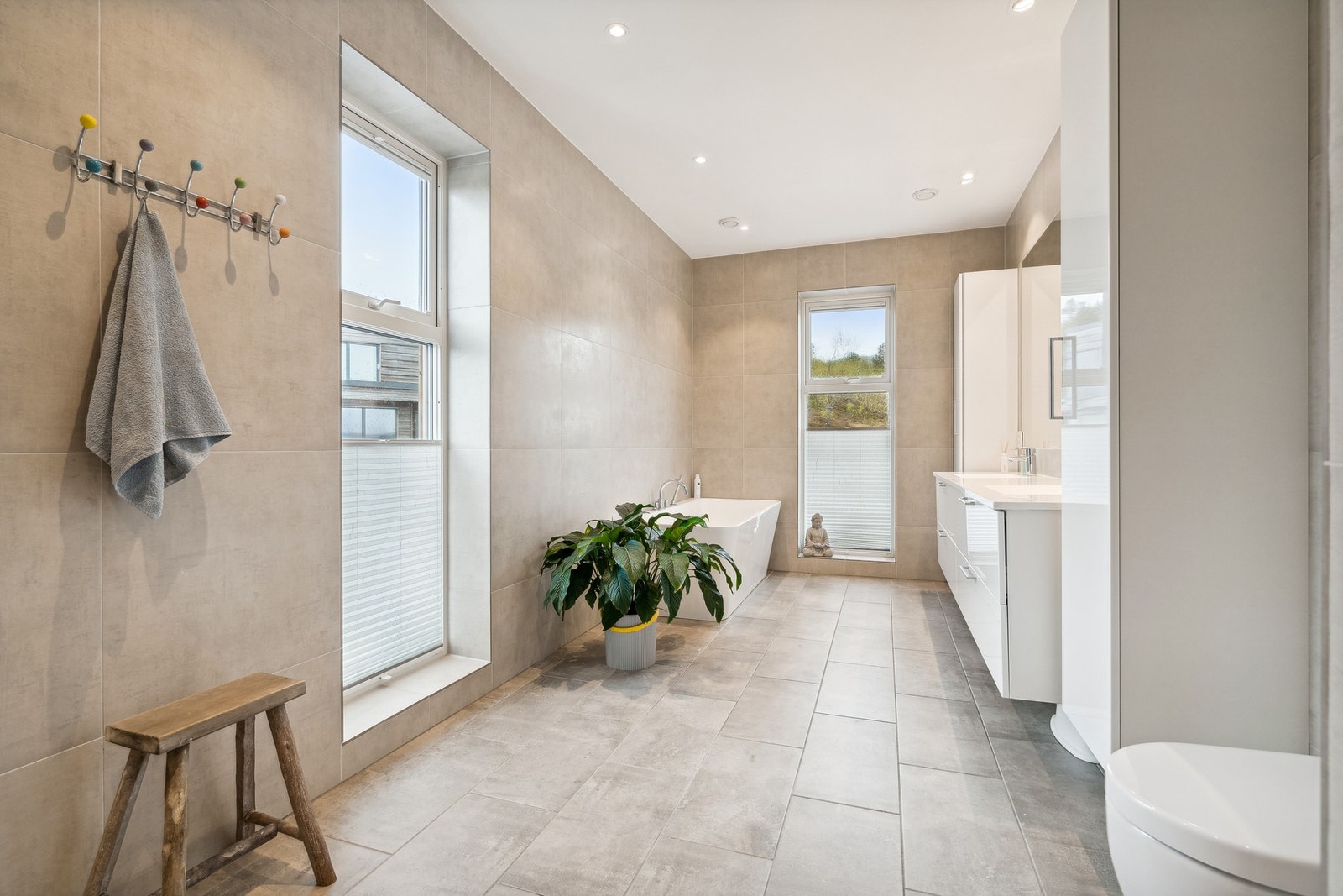 Delikat bad! Her får du flislagt gulv med varme, det er 60x60 fliser på vegger og slett malt tak med innfelte spotter Galleribilde