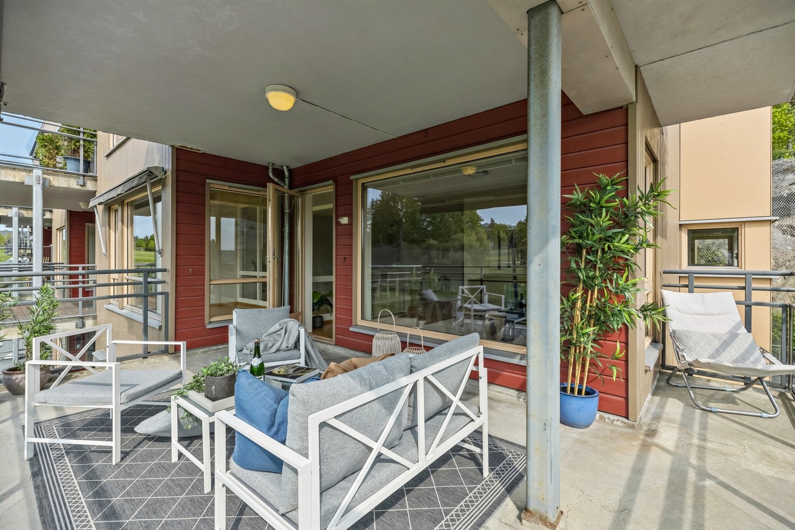 Overbygd terrasse med betongdekke, rekkverk i stål og glassfelt. Galleribilde