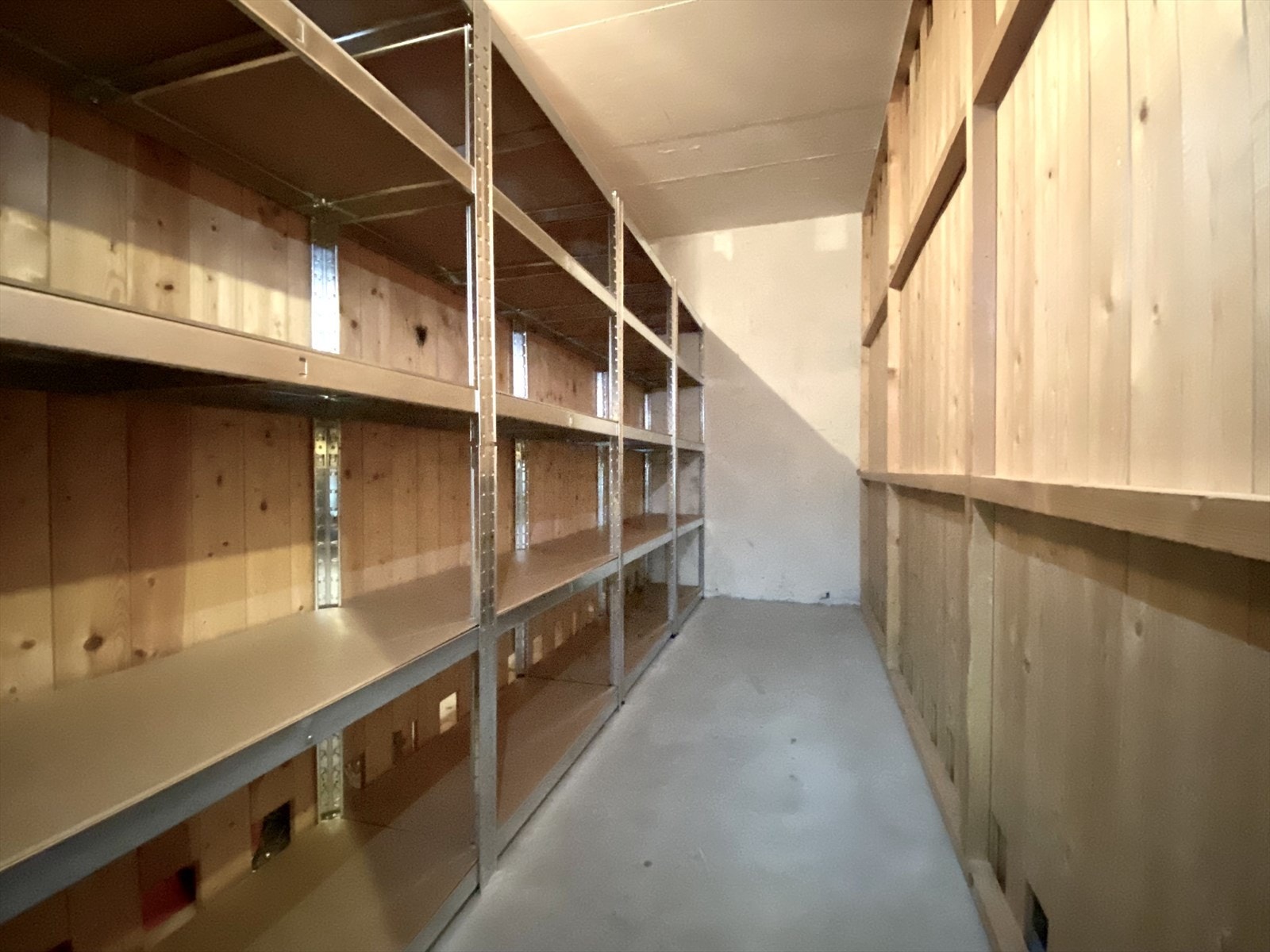 Medfølgende bod i kjeller. Her er det plass til hyllesystem og oppheng for sykler. Det medfølger også skap i kjølerom. Galleribilde