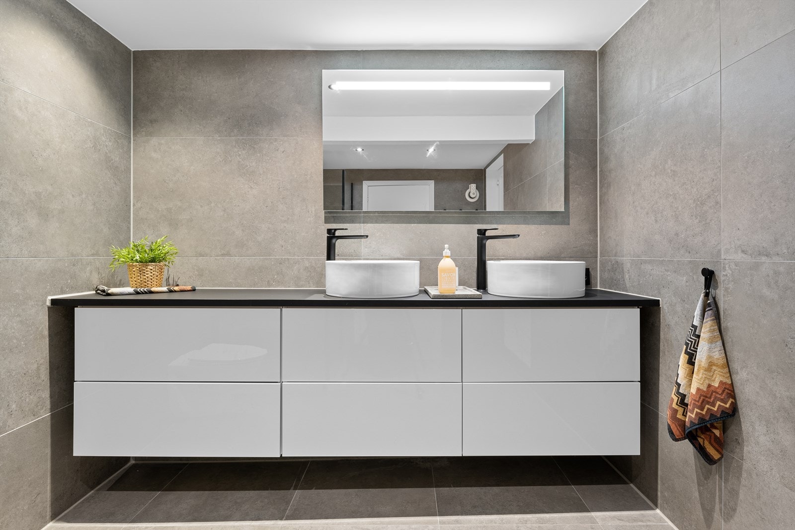 Badet ble pusset opp i 2020 og er delikat med store fliser på gulv og vegger, downlights, mekanisk avtrekk og sorte detaljer. Galleribilde