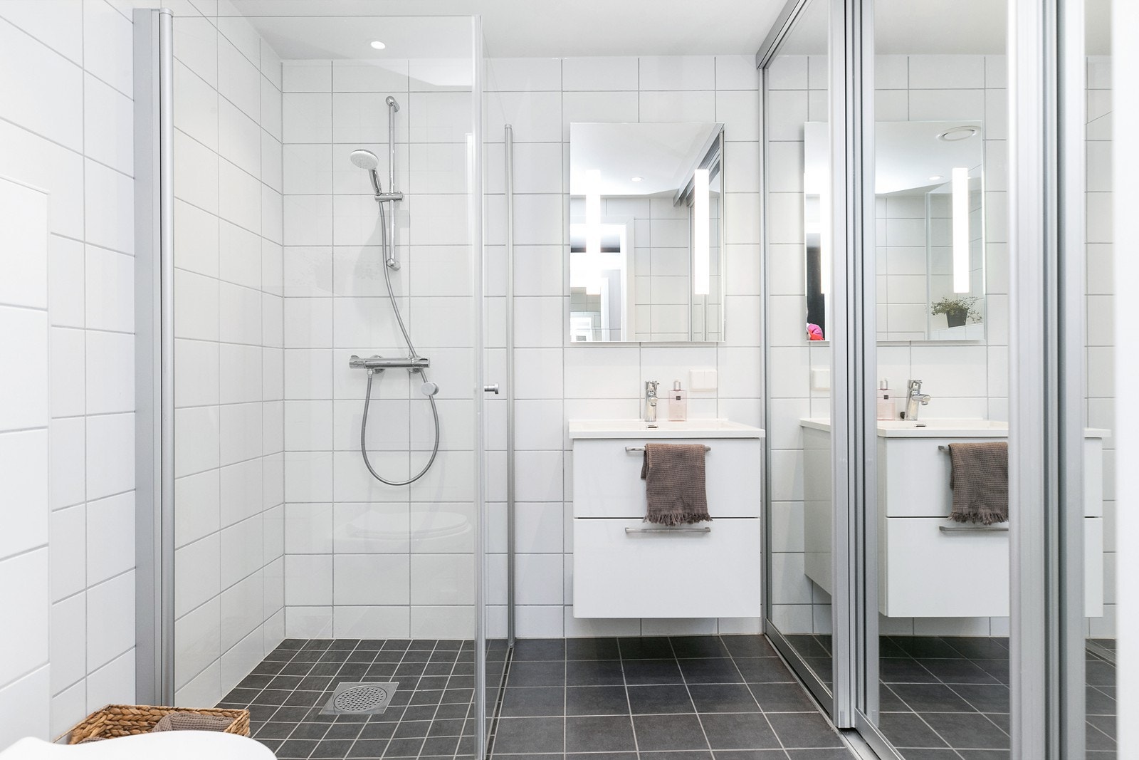 Flislagt dusjbad/wc i 1. etg. Vaskemaskin og tørketrommel bak speil-skyvedører Galleribilde