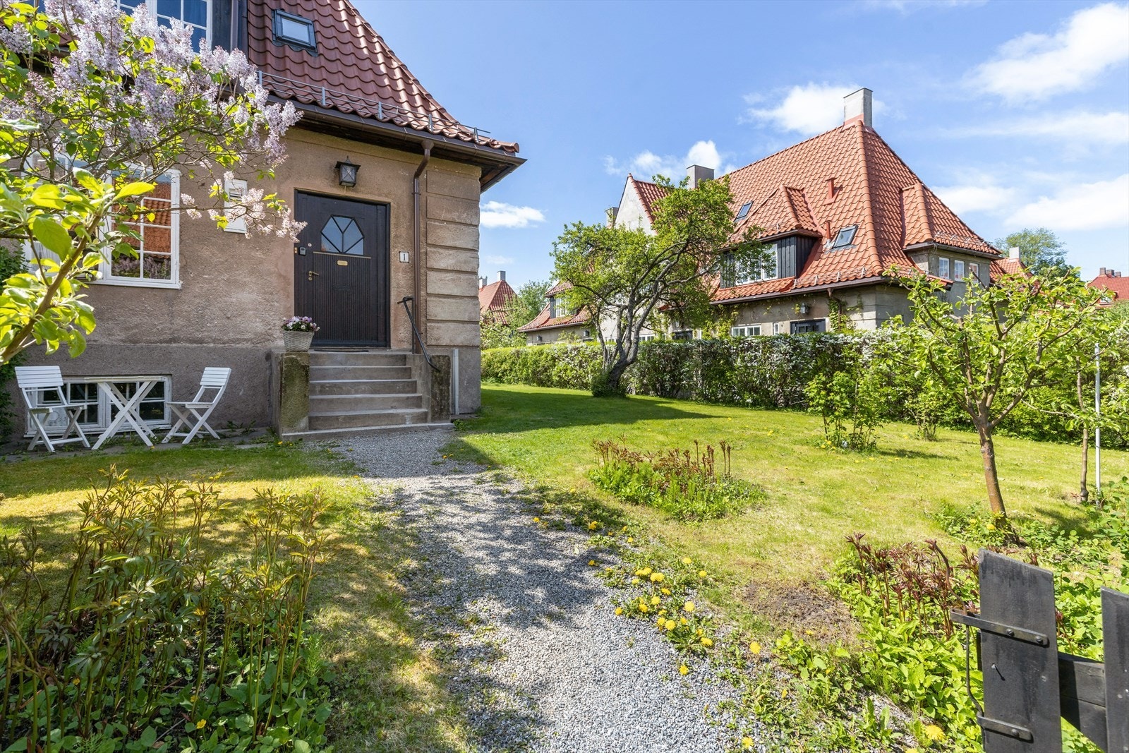 Eiendommen har en stor hage som strekker seg fra fremsiden og rundt hele boligen, innrammet med hekker og gjerde. Galleribilde