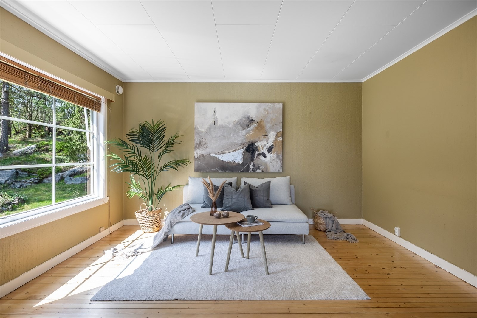 I stuen er det lakket furugulv og malt tapet på vegger i lun, moderne farge. Galleribilde