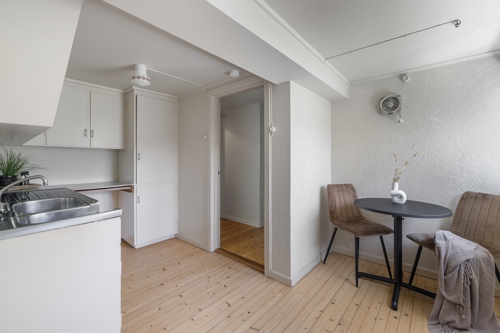 Kjøkkenet har skråstilt overskap med glatte fronter og heldekkende stålvask med skyllekum. Galleribilde