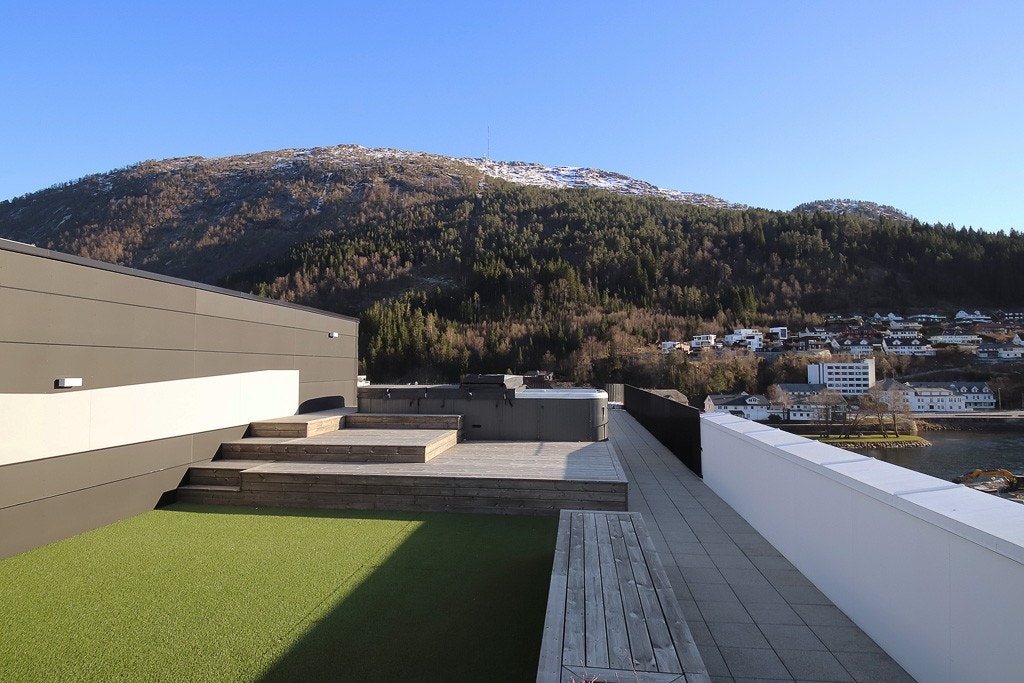 Takterrassen er opparbeidet med beplantning, felt av kunstgress, soldekk og benker (arkivfoto) Galleribilde