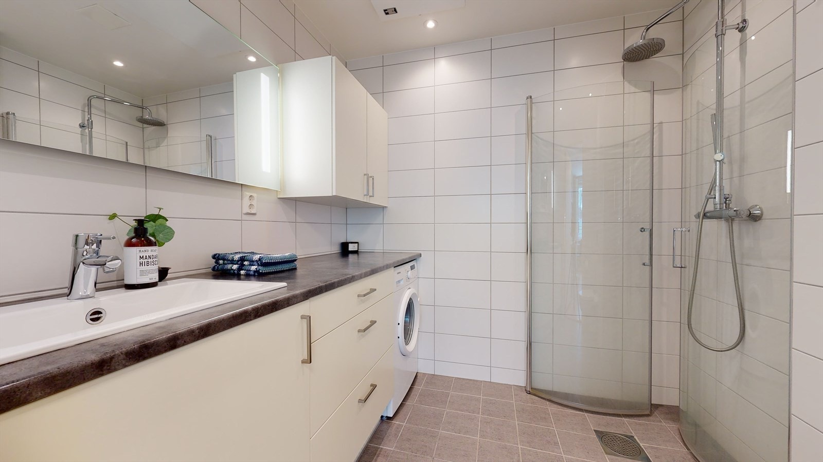 Badet er stilrent og har innfellbare dusjvegger, tohodet dusjbatteri og veggfestet WC Galleribilde