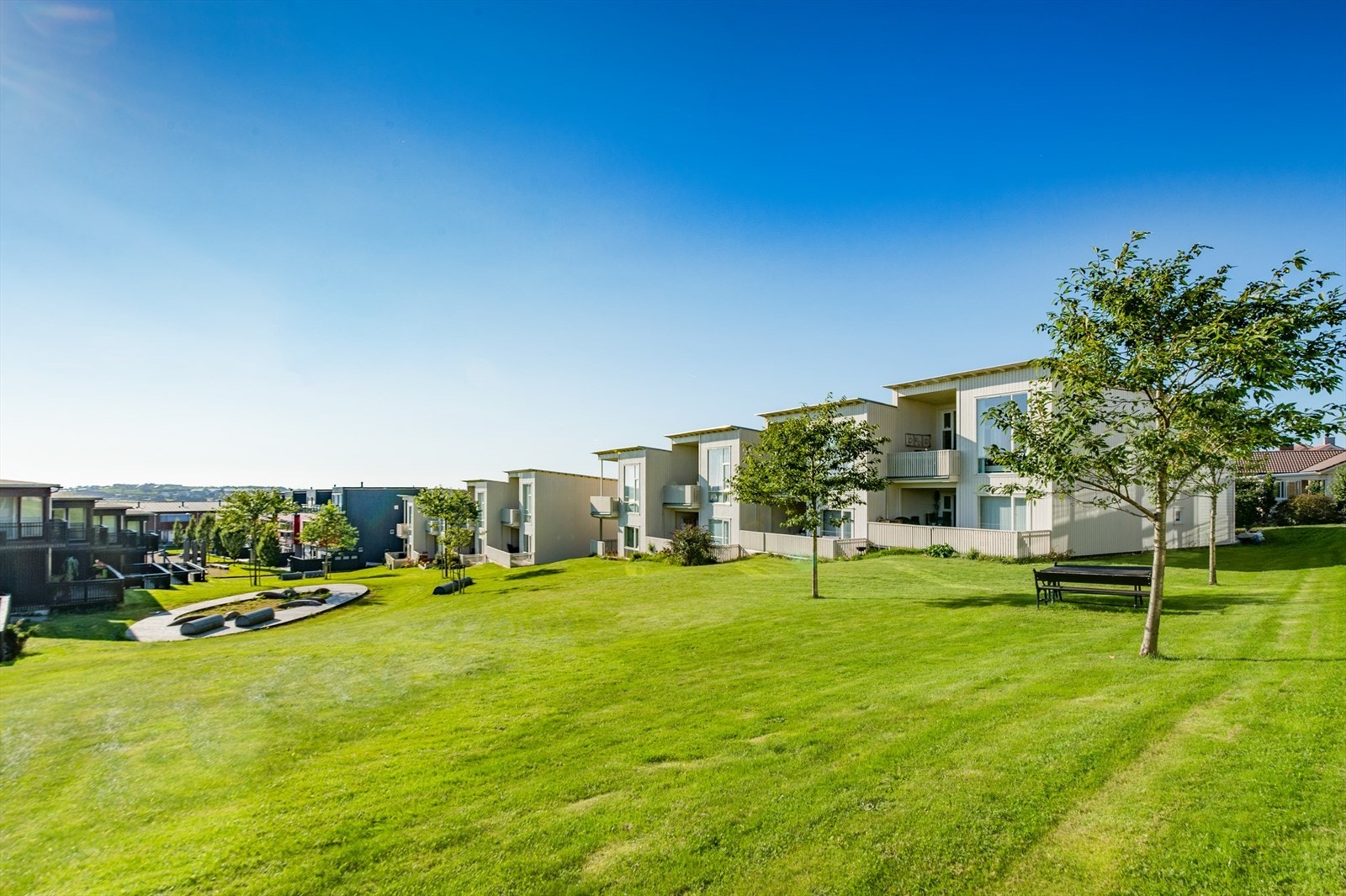 Pent opparbeidet tomt for beboerne i Borettslaget med plenareal og diverse beplantning. Galleribilde