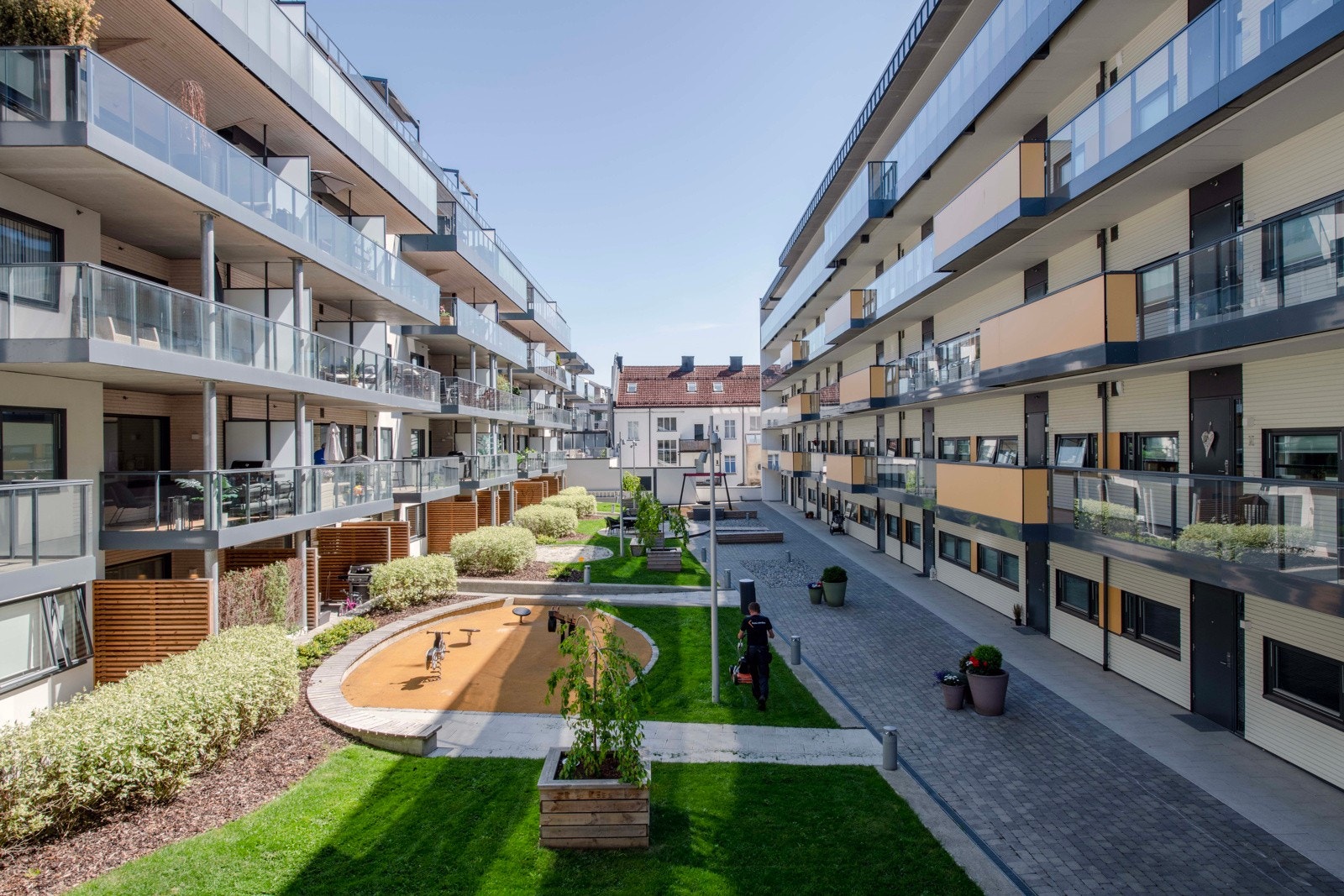 Det er gruslagte arealer, steinsatte partier, belysning og felles sittebenker. Galleribilde