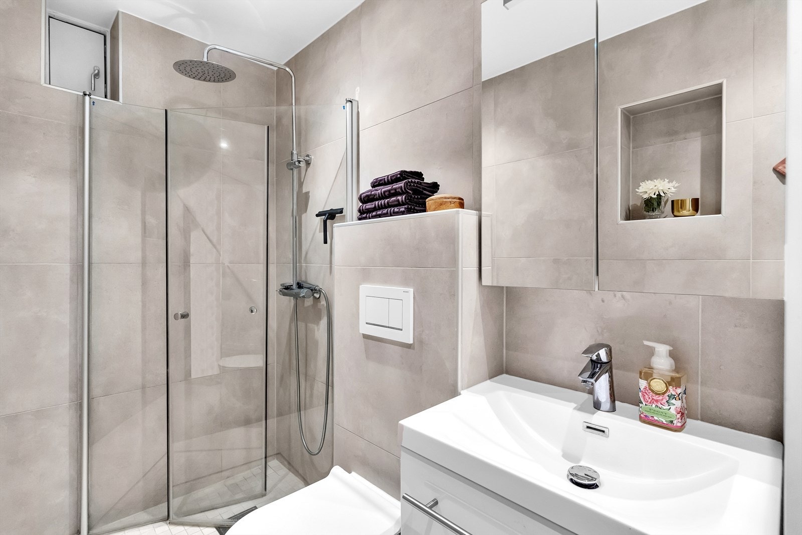 Totalrenovert bad (2020) flislagt på gulv og vegger med en smakfull jordtone. Galleribilde