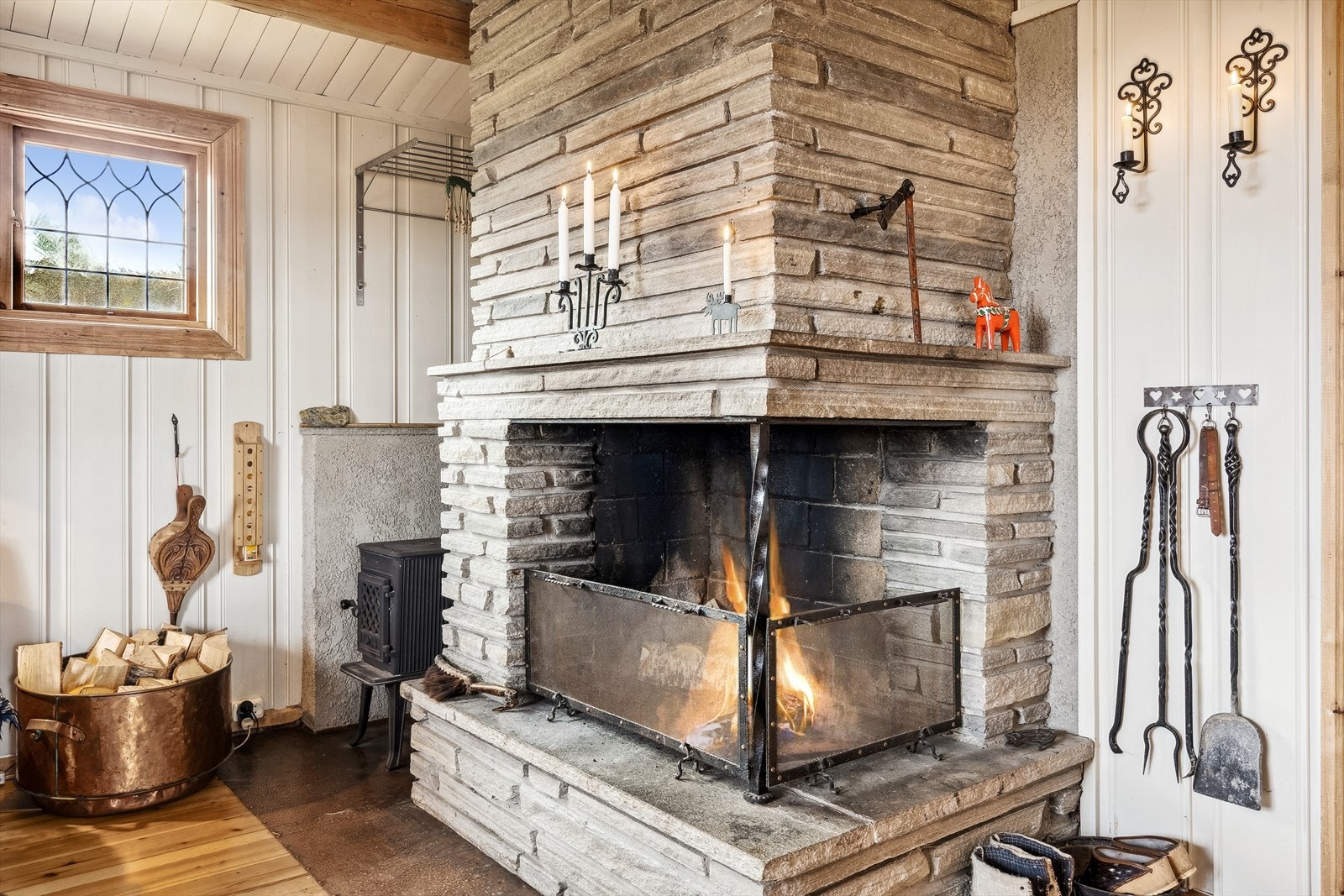 I stuen er det en stor åpen gruepeis forblendet med naturstein og vedovn på siden, som gir god varme og en lun atmosfære. Galleribilde