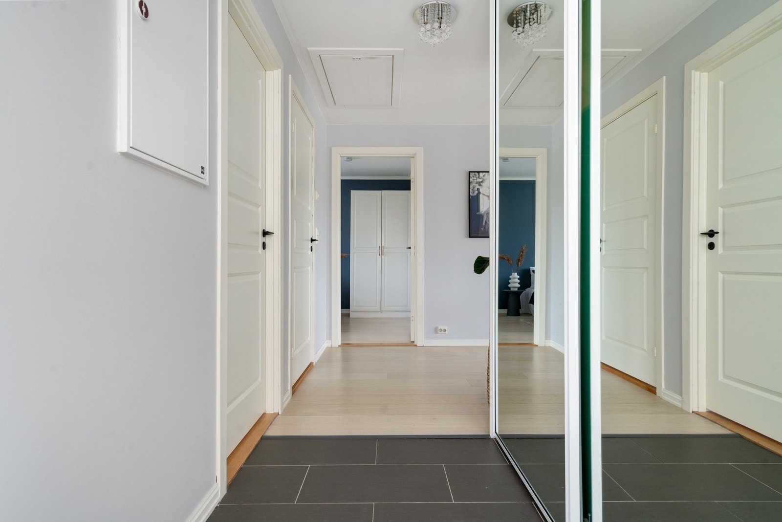 Flislagt entré med oppbevaring i skyvedørsgarderobe. Galleribilde