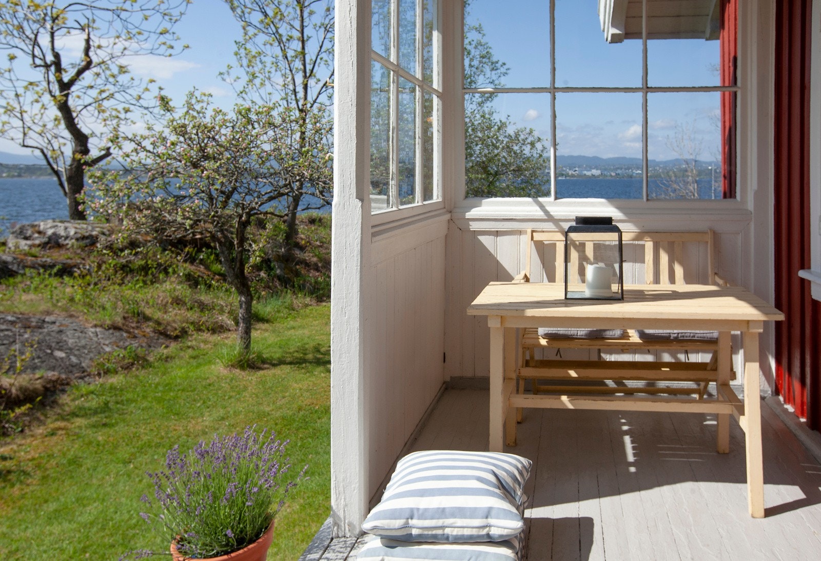 Deler av verandaen ut mot den frodige hagen er skjermet med smårutet glass. Galleribilde