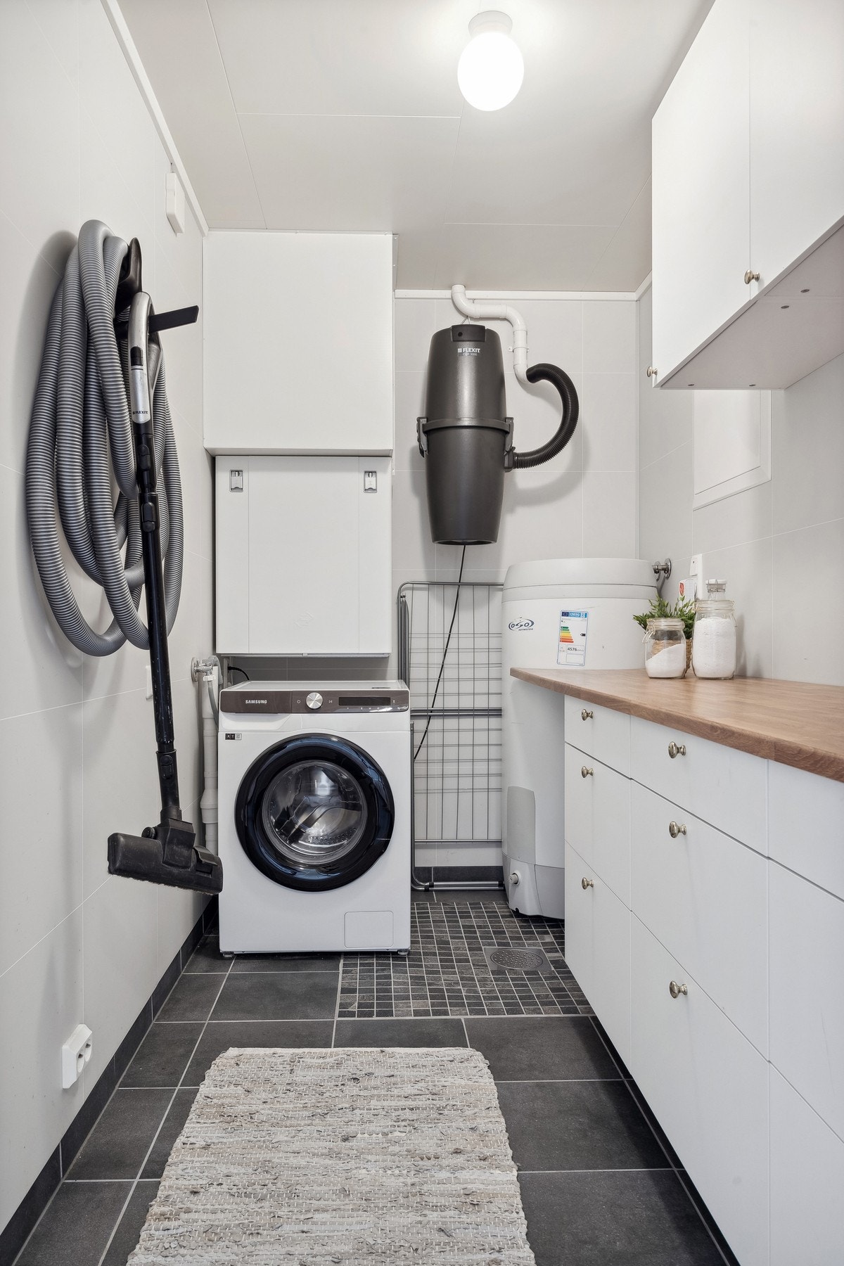 Praktisk vaskerom/teknisk rom med innredning, benk og overskap. Boligen har balansert ventilasjonsanlegg med varmegjenvinning. Galleribilde