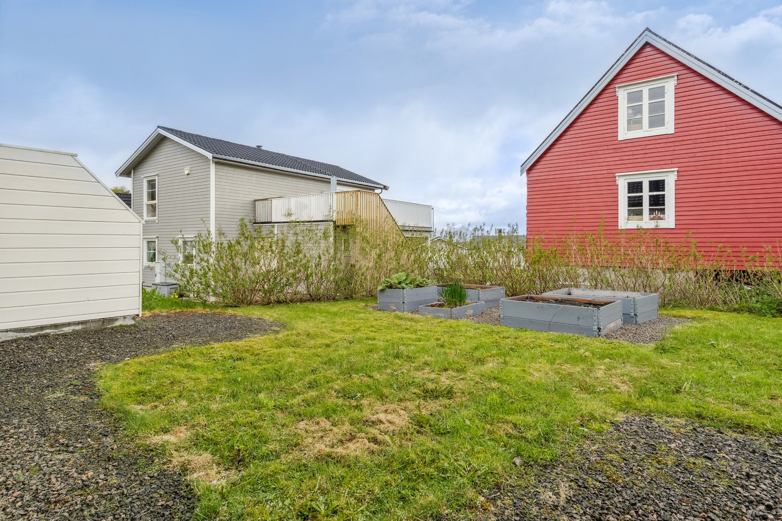 Tomta er pent opparbeidet med plen og hekk. Pallekasser med jordbærplanter, rabarbra og gressløk - her har du kortreist mat i hagen! Galleribilde