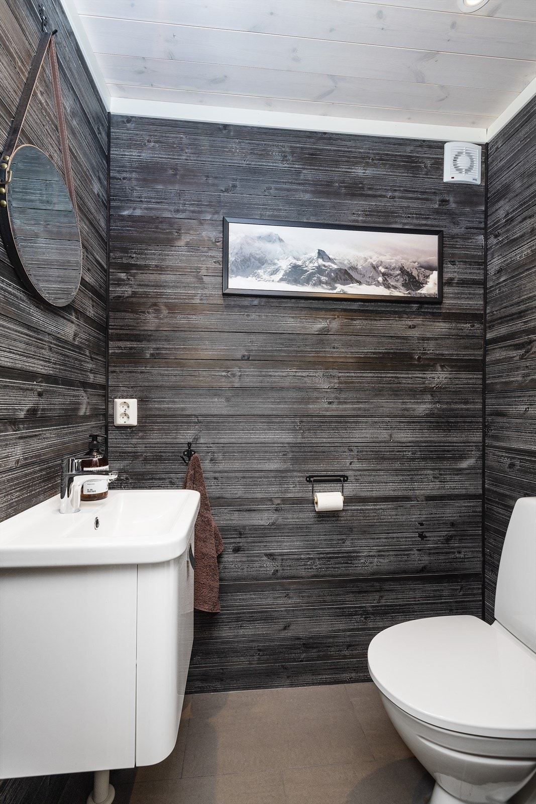 Koselig toalettrom med servant og gulvstående toalett. Galleribilde