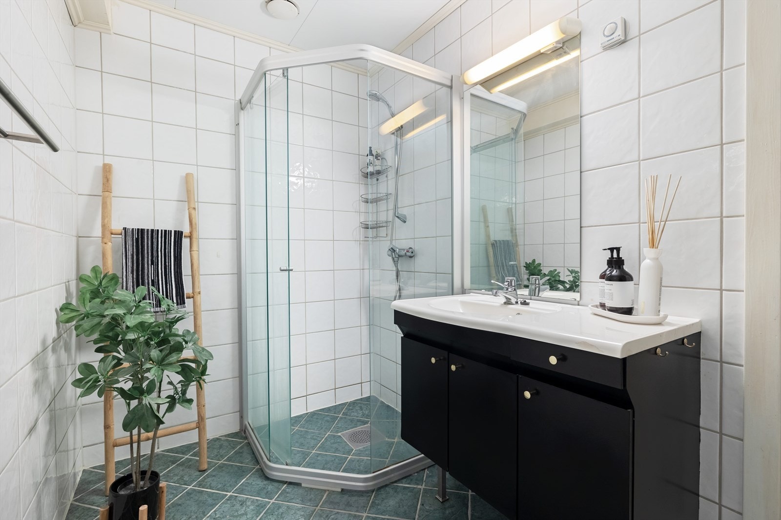 Badet er innredet med servant og dusjhjørne. Det er også opplegg for vaskemaskin og tørketrommel her. Galleribilde