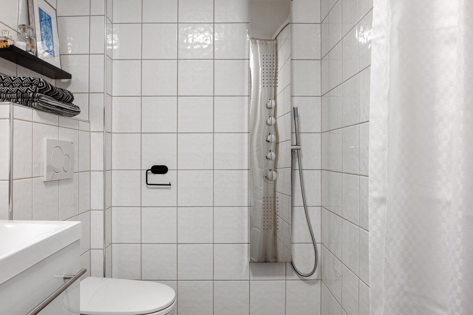 Badet er innredet med dusj, vegghengt toalett og baderomsinnredning.. Galleribilde