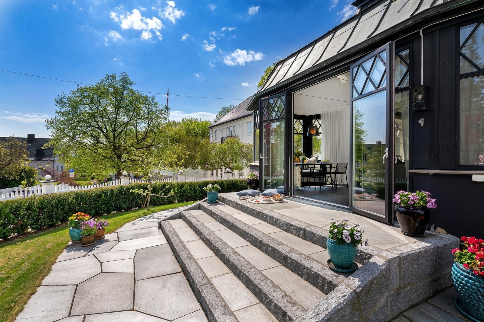 Hjørnetomt som er vakkert opparbeidet med have, terrasse og balkong, for en idyllisk tilværelse sommerhalvåret Galleribilde