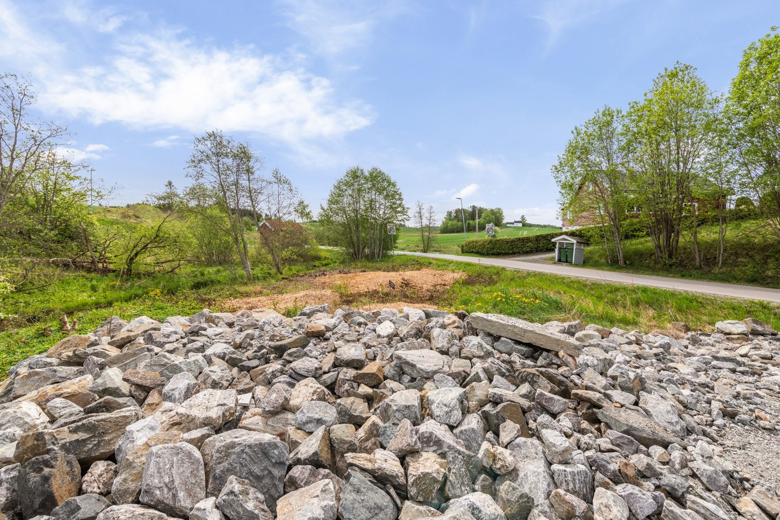 Deler av tomten mot øst er planert med steinmasse i fm. anleggelse bygging/anleggelse av gårdsplass av 2-mannsboligen i Klokkerudåsen 4 A-D. Galleribilde