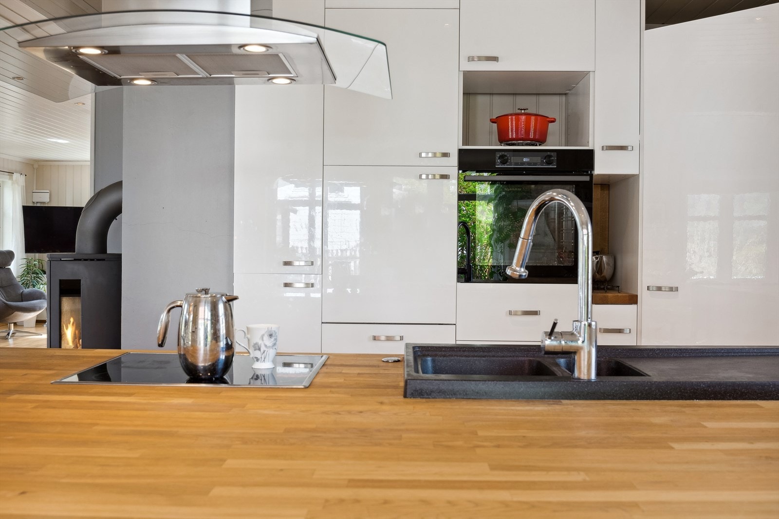 Flott, stilrent kjøkken med innredning med høyglans fronter, heltre benkeplate og benkebeslag. Galleribilde